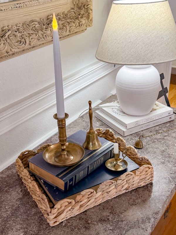 Simple winter entry table decorations. Basket tray, books in color blue and brass candle holder.