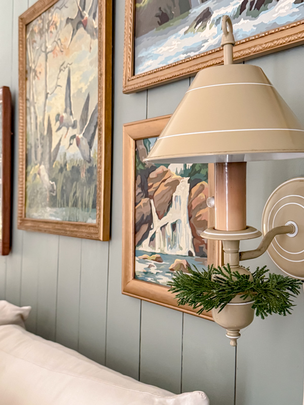 Wall lamp decorated for winter with a mini cedar wreath on the bottom