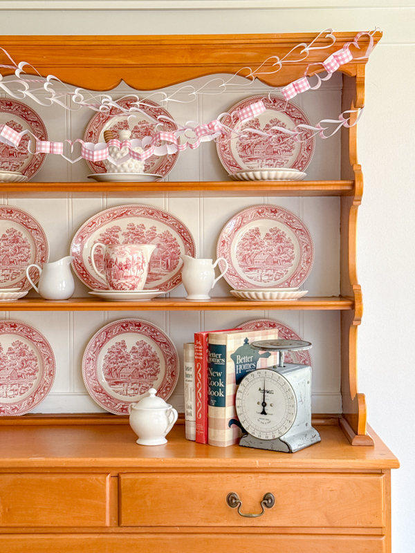 Dining room decorations of heart paper chains on a china hutch