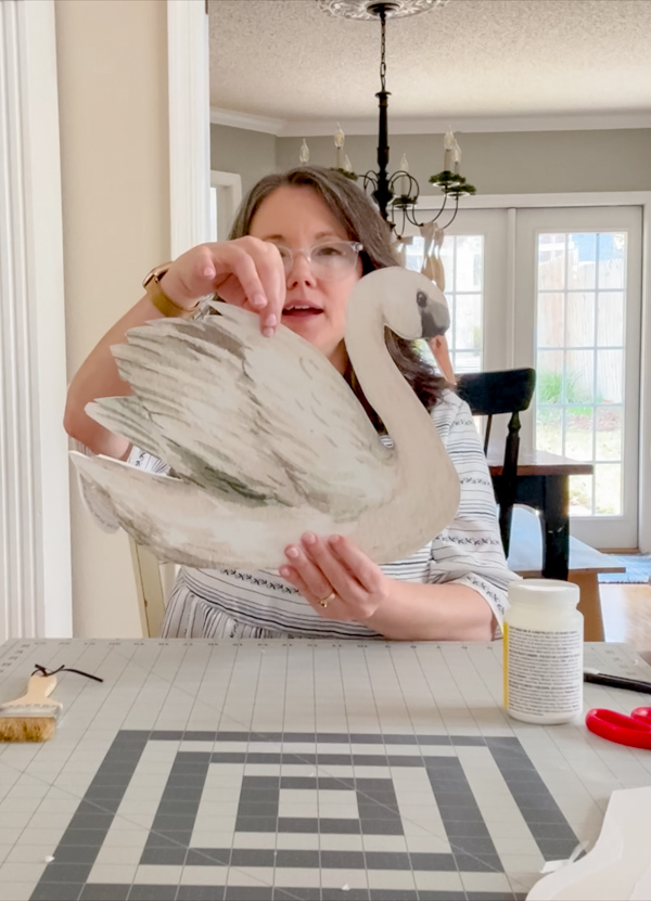 Holding a swan printable to determine the best place to put a hole for hanging