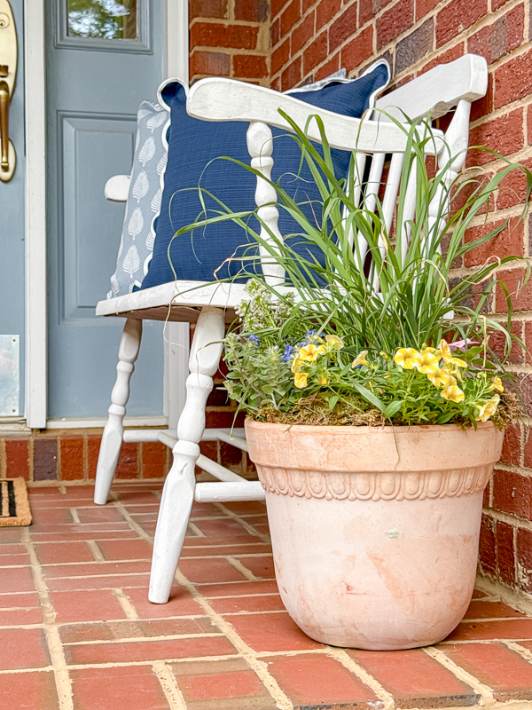 A clean and minimal spring porch refresh with white bench, terracotta pots, and new doormat.