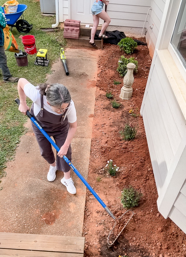 Smoothing the ground around a newly planted flower bed
