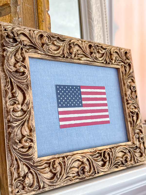 American flag printable printed on watercolor canvas paper and framed in an ornate frame with a chambray fabric background showing the soft painterly quality of watercolor canvas printing
