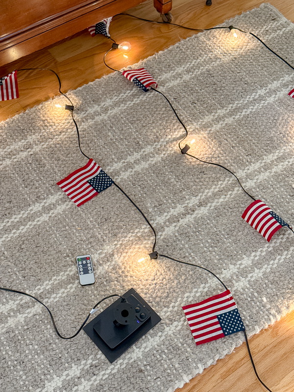 DIY American flag string light garland laying on a floor rug.