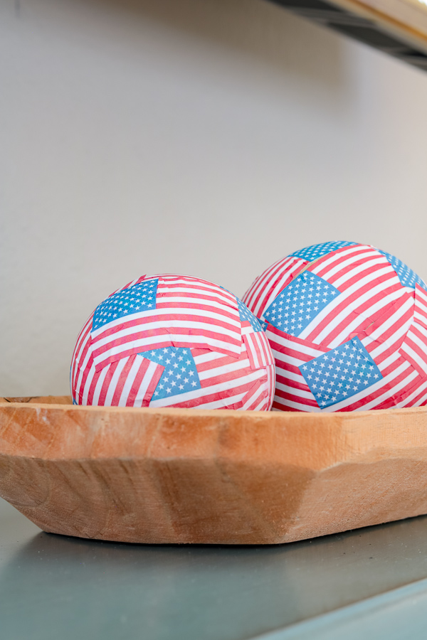 Wooden dough bowl filled with mini American flag balls.