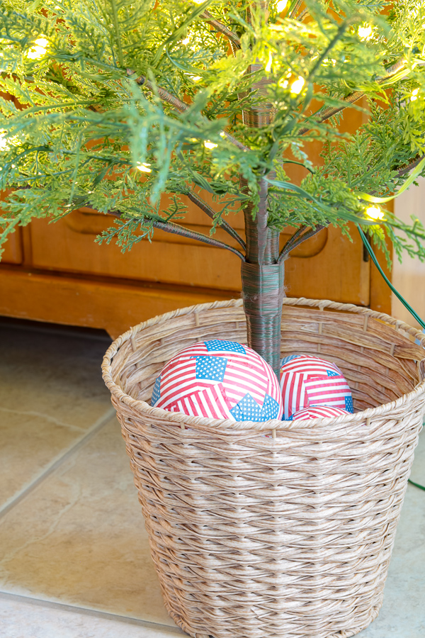 Bucket of a Christmas tree with red, white and blue flag ball ornaments