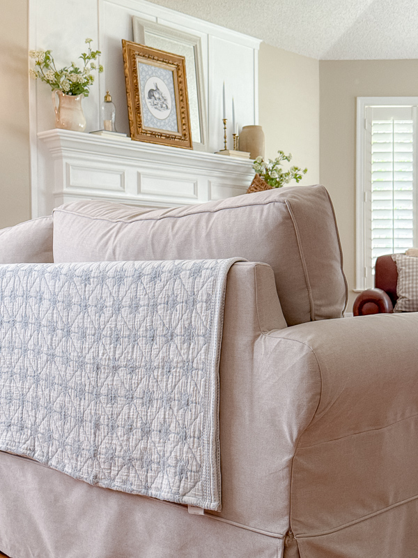 Blanket on back of sofa in a living room in a french country farmhouse style.