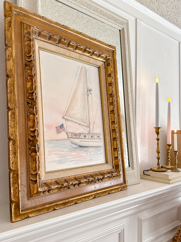 Watercolor sailboat printable in an ornate gold vintage frame on a white mantel for Ralph Lauren Americana home decor