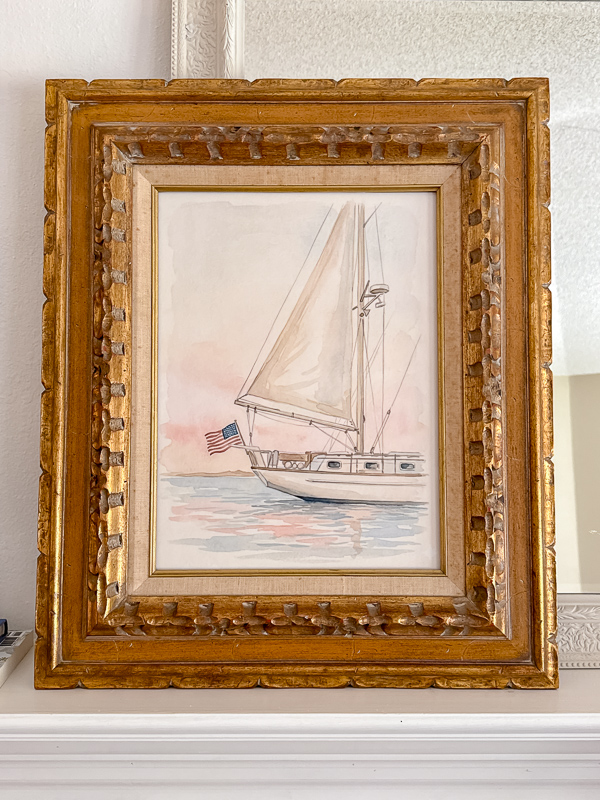 Watercolor sailboat printable in an ornate gold vintage frame on a white mantel for Ralph Lauren Americana home decor
