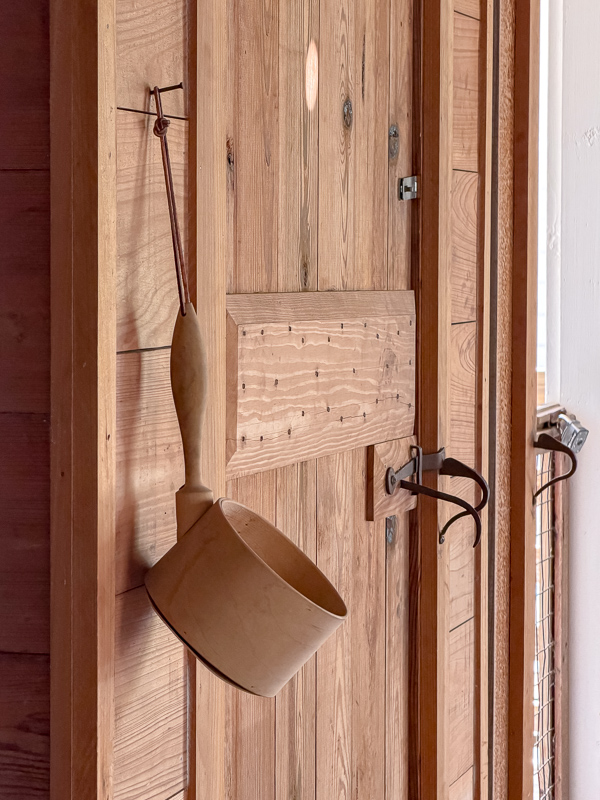 Wooden ladle hanging from a nail on a plank door