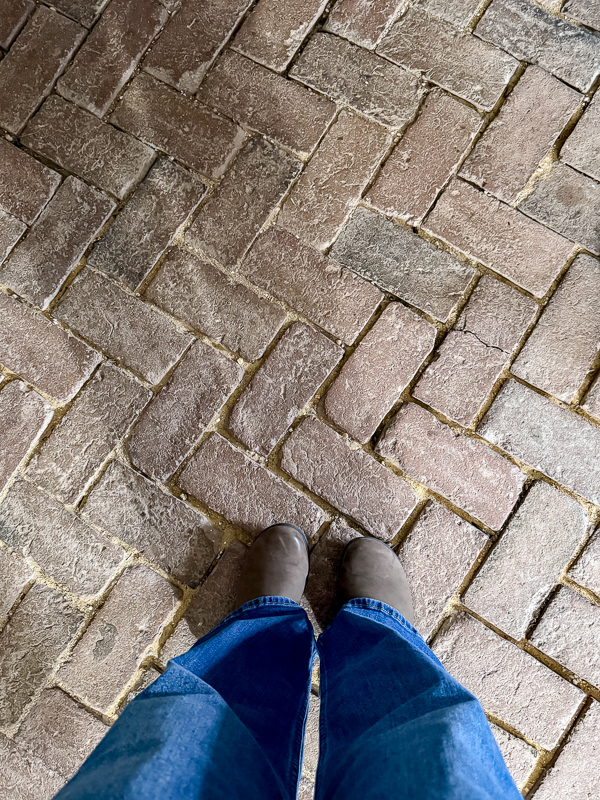 Brick flooring layed in herrington pattern most likely in an old house kitchen.