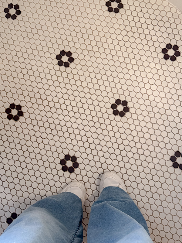 Old white hexigon tile floor in white with black tiles in a flower pattern. This floor was found at Williamsburg in the Robert Carter house you can stay in.