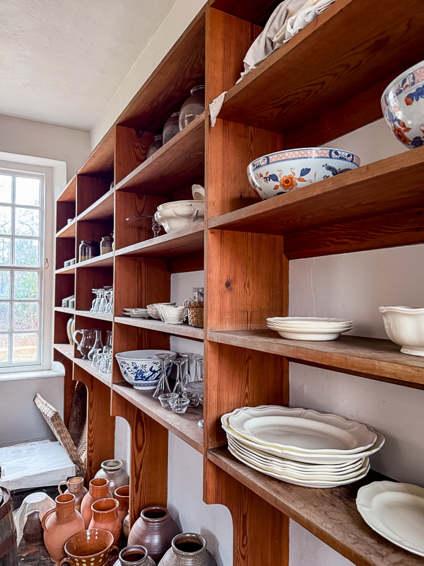 Built-in pantry shelving styled with ironstone and blue and white china