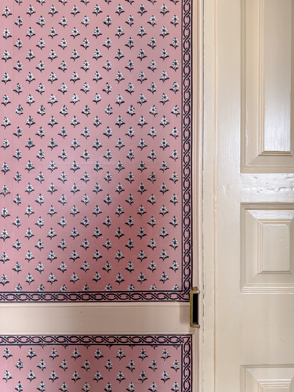 Pink floral block print wallpaper with a navy border idea for a newer home.