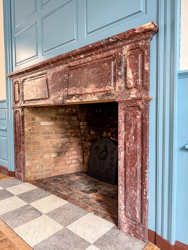 Marble mantel idea for a new home with a raised panel trim design on top and trim on the sides. This mantel was found at Williamsburg.