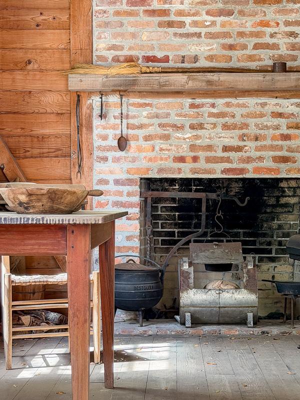Idea of an old fireplace to use in your new home. Brick with a handmade cross mantel and notice the fireplace box opening goes all the way to the ground.