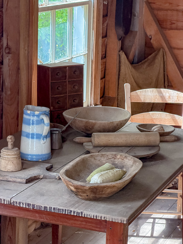 Old wood table with dough bowls, salt glaze pitcher, wooden rolling pins and more found in the kitchen at Belleview. Idea for accessories for making a newer house look old.