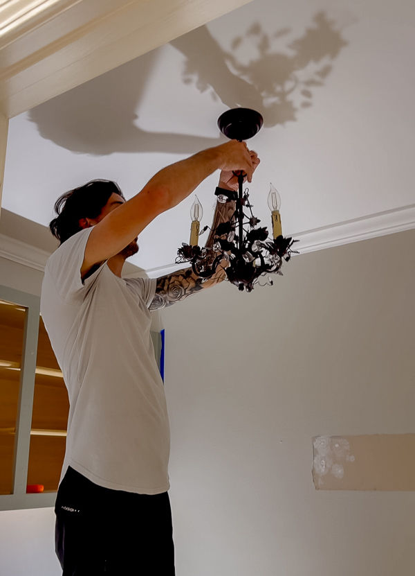 Fancy chandelier of bronze ivy in a whimsical cottage garden laundry room.