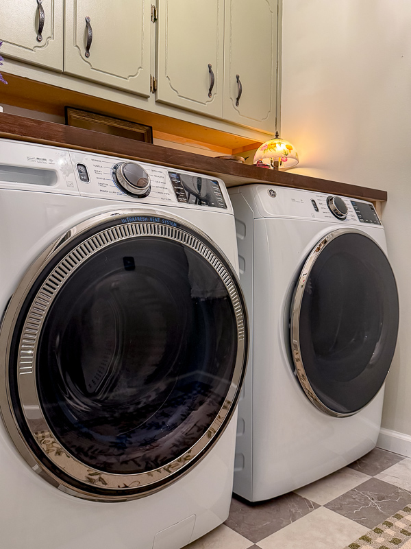 GE front load washer and dryer in a vintage cozy cottage garden theme laundry room