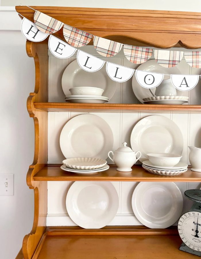 Plaid scallop garland layered with a Hello Autumn letter garland on a wooden hutch