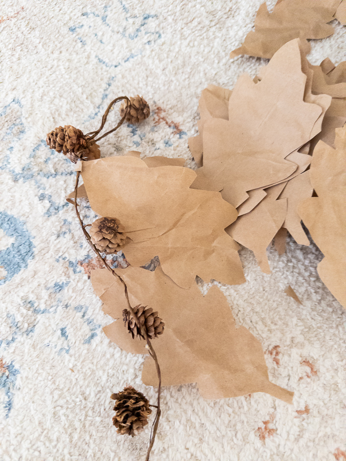 Making a paper leaf garland out of Amazon brown packing paper using a mini pinecone fiary light garland