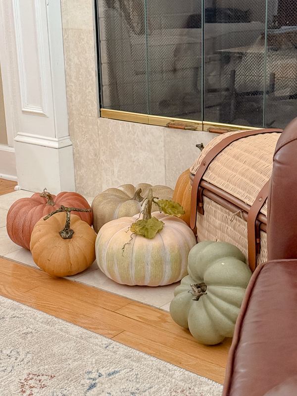 Realistic faux pumpkins on a fireplace hearth